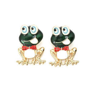 Macro detail of frog earring featuring green enamel finish and red rhinestone bow tie