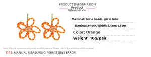 Vue détaillée des boucles d'oreilles fleur orange en perles de verre faites main