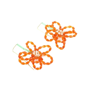 Détail de boucles d'oreilles fleurs en perles orange avec crochets tissés verts