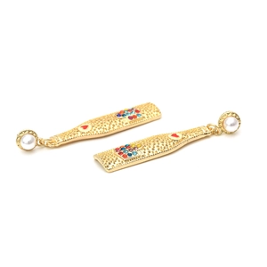 Nahaufnahme der goldenen Sektflaschen-Ohrringe mit Strass und Perlendetails