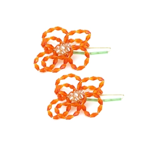 Détail de boucles d'oreilles fleurs en perles orange faites main avec tiges vertes