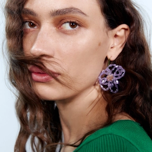 Boucles d'oreilles fleurs en perles de cristal violet avec crochets dorés sur mannequin