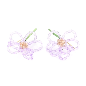 Détail de la boucle d'oreille fleurie en perles violettes avec accents de tige verte