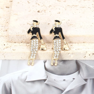 Boucles d'oreilles dorées avec figurines de femmes abstraites en émail noir et strass brillants