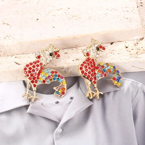 Boucles d'oreilles coq exagérées avec strass colorés sur une monture en métal doré