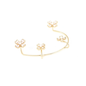 Exaggerated gold metal flower ear cuff for women with elegant pearl accents on white background