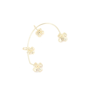Detailed view of golden curved ear cuff featuring four textured clover motifs on white background
