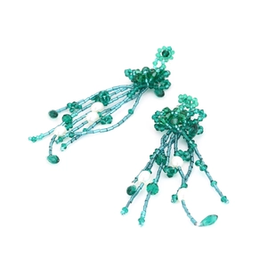 Handmade beaded tassel earrings with green crystals and white pearls on white background