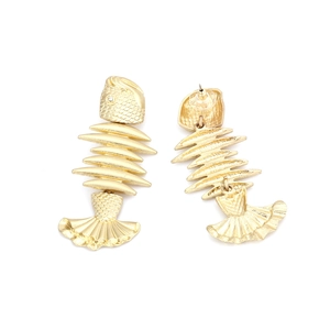 Macro shot of gold fishbone earrings with scales texture and rhinestone eyes