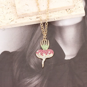 Cute golden carrot pendant necklace with pink and green crystals on elegant stone background