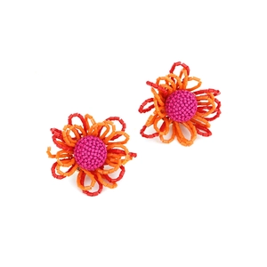 Dettaglio di orecchini a fiore fatti a mano con perline rosse e arancioni stile boho