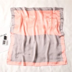 Dettaglio di un foulard di seta con blocchi di colore arancione e grigio e trama liscia