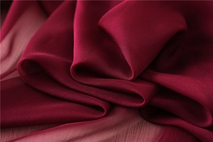 Detalle macro de bufanda de gasa rojo vino con textura de seda y elegantes pliegues suaves