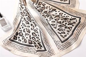 Macro detail of silk-like scarf featuring leopard print with polka dot and grid patterns
