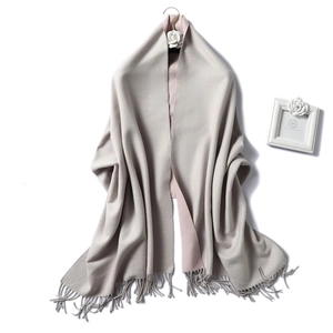 Detail of soft double-sided scarf with pink and beige fringe on a golden hook
