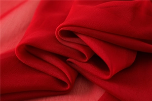 Detalle de tela suave roja efecto seda que muestra una textura delicada y caída elegante