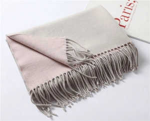 Detail of soft gray and pink cashmere-like scarf showing dual-sided texture and fringe
