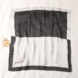 Dettaglio di elegante foulard di seta bianco e nero con motivo geometrico e finitura lucida
