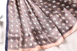 Detail of silk-like scarf featuring equestrian horse prints and elegant rolled edges