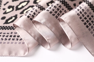 Close-up of leopard print and geometric patterns on a smooth faux silk square scarf