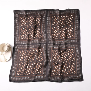 Detailed view of leopard print silk scarf with checked pattern and elegant coffee cup setup