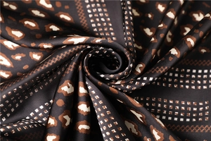 Detailed view of silk-like leopard and geometric plaid pattern with a soft glossy texture