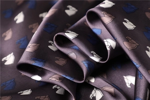 Detailed close-up of premium silk scarf with elegant horse head print and satin finish