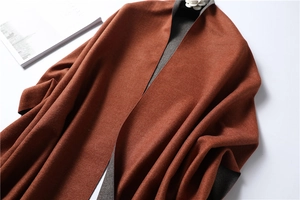 Detail of double-sided cashmere scarf in caramel and grey with luxury camellia decor