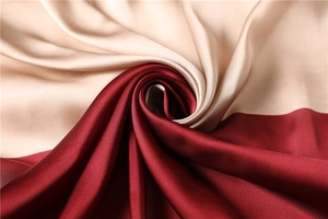Dettaglio di un foulard in raso di seta con design color block champagne e bordeaux