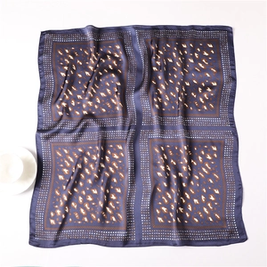 Detail of blue leopard print silk square scarf showing smooth satin texture and elegant drape