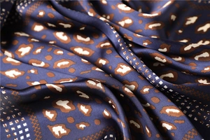 Macro shot of dark blue leopard print silk scarf featuring elegant geometric patterns