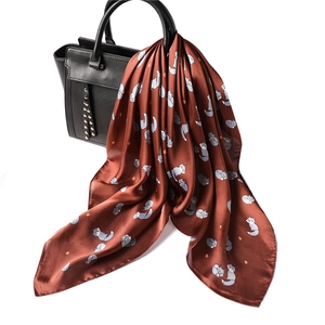 Terracotta silk scarf with cute fox and stars print tied on a black handbag handle
