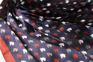 Detailed close-up of premium satin silk scarf with vintage equestrian horse head patterns