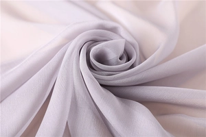 Vista detallada de un chal de gasa violeta claro con elegantes pliegues en forma de rosa