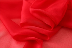 Texture dettagliata di una sciarpa in chiffon rosso con pieghe e lucentezza morbida