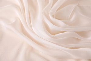Detalle macro de la tela sedosa blanco crema con caída suave y brillo sutil elegante
