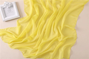Texture dettagliata della sciarpa in chiffon giallo chiaro con pieghe morbide