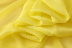 Vista dettagliata del tessuto chiffon stropicciato giallo con drappeggio naturale morbido