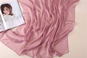 Detalle del pañuelo de gasa rosa con pliegues suaves y acabado translúcido ligero