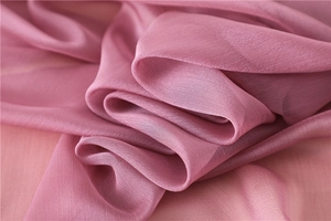 Detalle de tela sedosa rosa con textura suave y elegantes ondulaciones horizontales