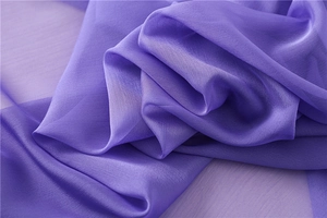 Dettaglio della trama del tessuto in chiffon viola con lucentezza serica e drappeggio