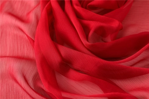Primer plano de textura de gasa roja brillante con drapeado suave y grano vertical fino