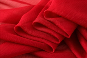 Primer plano de tela de gasa plisada roja que muestra su textura y caída elegante