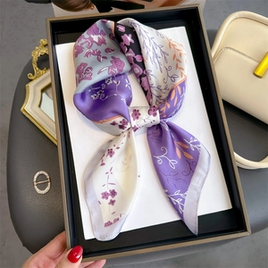 Élégant foulard en soie à imprimé floral violet plié dans un coffret cadeau
