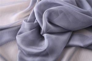 Primer plano de tela de gasa violeta claro con textura vertical y caída delicada