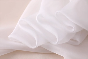 Detalle macro de tela blanca sedosa y ligera con textura elegante y caída suave y fluida