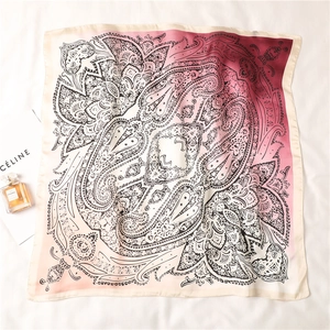 Macro detail of silk-like paisley square scarf with pink gradient and mandala patterns