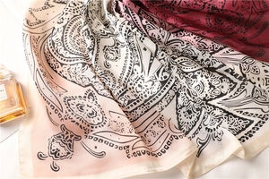 Close-up of dual-tone gradient silk scarf with detailed paisley patterns and smooth texture