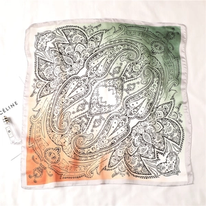 Detailed close-up of paisley pattern on gradient orange and green square silk scarf