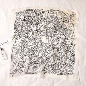 Flat lay of silk-satin square scarf with black paisley and floral prints on beige base